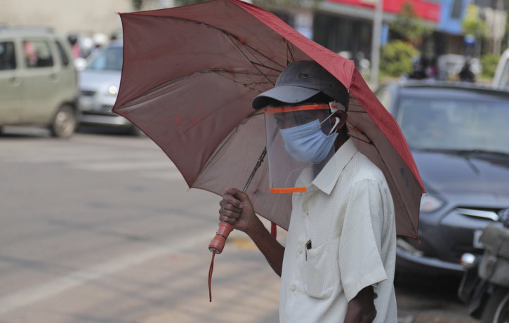 A man wearing a face shield as a precautionary measure against the coronavirus walks on a street in Hyderabad, India, Tuesday, Oct. 27, 2020.