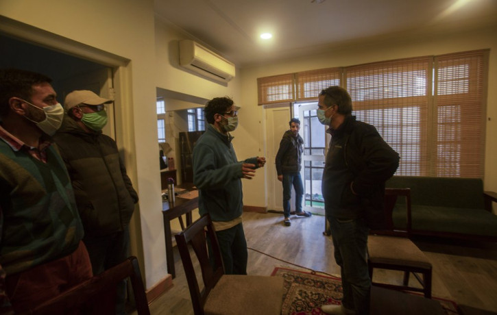 Agence France-Presse’s Kashmir correspondent Parvaiz Bukhari, centre, talks to his colleagues after National Investigation Agency personnel searched his premises on the outskirts of Srinagar,