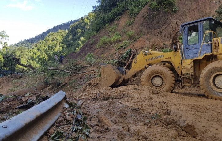 A bulldozer clears out the road damaged by landslide to access a village swamped by another landslide in Quang Nam province, Vietnam on Thursday, Oct. 29, 2020.
