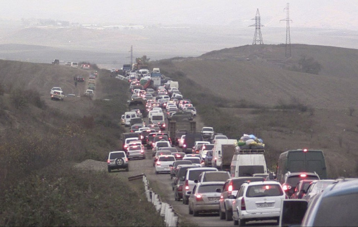 In this photo taken from the Associated Press Television video, people stuck in a traffic jam as they leave the separatist region of Nagorno-Karabakh to Armenia, Saturday, Nov. 7, 2020.