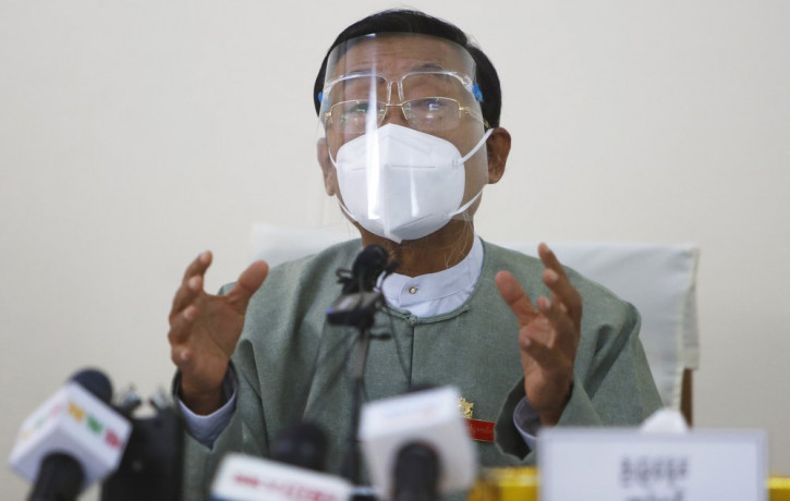 Myint Naing, a member of the Union Election Commission, wearing a protective face mask and shield, gestures as he delivers a speech during an event to announce election results Wednesday, Nov