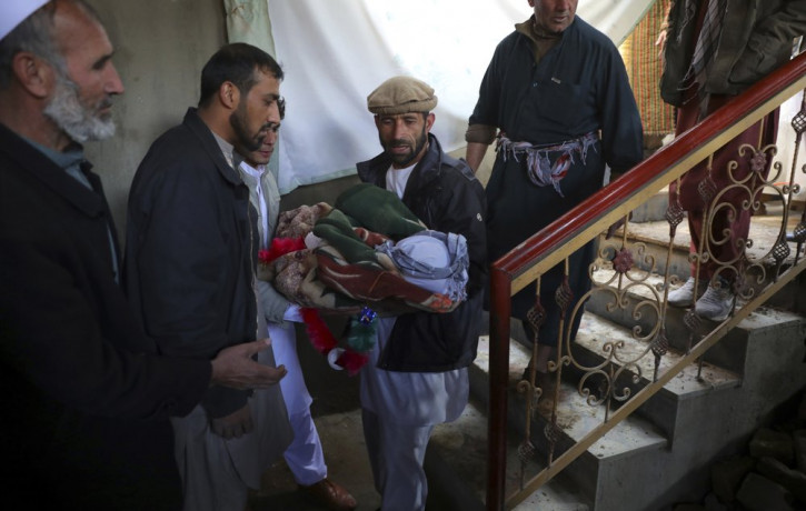 Relatives carry the dead body of a boy who was killed by a mortar shell attack in Kabul, Afghanistan, Saturday, Nov. 21, 2020. Mortar shells slammed into different parts of the Afghan capital