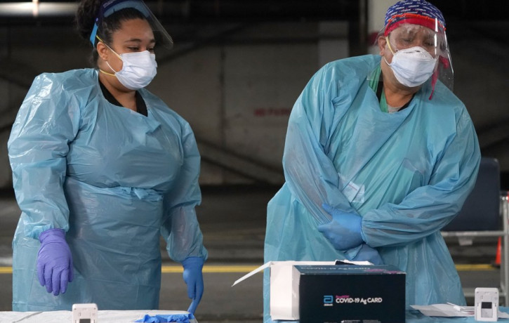 Nurses check on the status of rapid COVID-19 tests at a drive-through testing site in a parking garage in West Nyack, N.Y., Monday, Nov. 30, 2020.