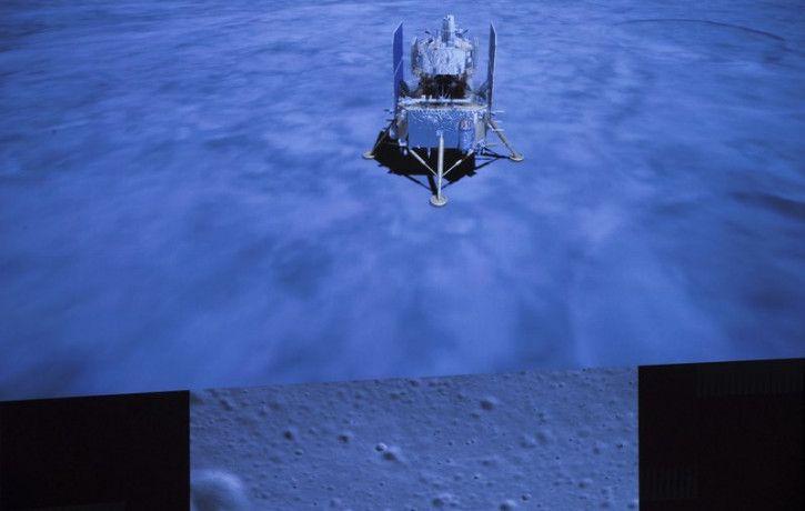 In this photo released by Xinhua News Agency, a screen shows the landed Chang'e-5 spacecraft and a moon surface picture, below, taken by camera aboard Chang'e-5 spacecraft during its landing 