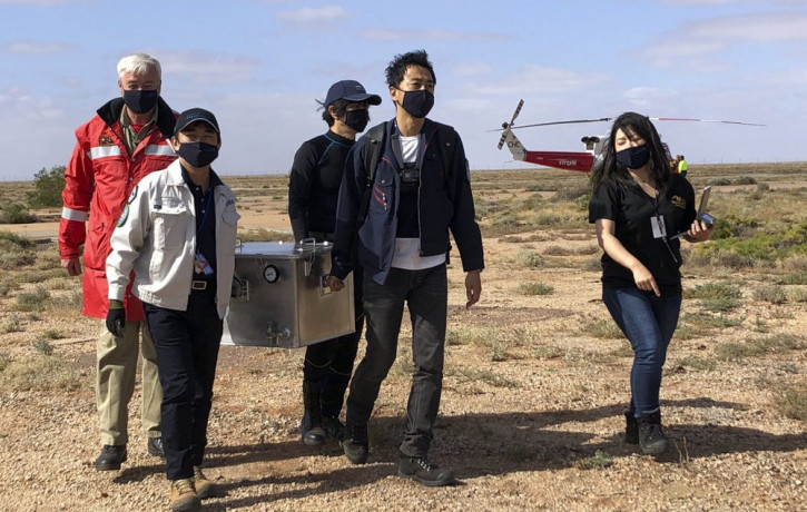 In this photo provided by the Australian Space Agency, members of the Japan Aerospace Exploration Agency (JAXA) arrive at a range support facility in Woomera, Australia, Sunday, Dec. 6, 2020,