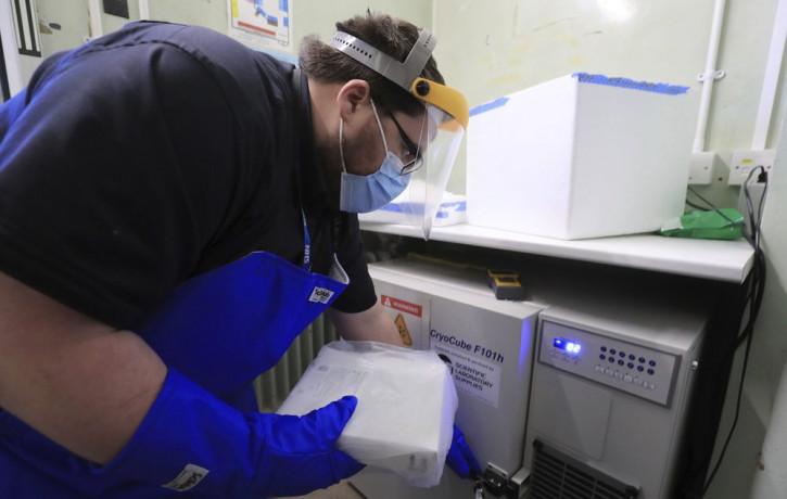 A pharmacy technician from Croydon Health Services prepares to store the first delivery of COVID-19 vaccine, with temperature at right reading minus 82, at Croydon University Hospital in Croy