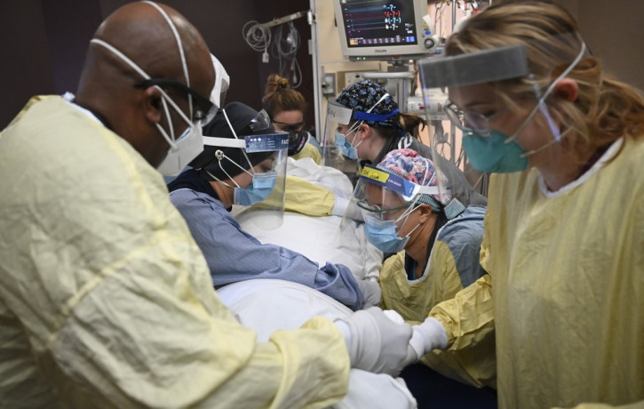 In this Monday, Dec. 7, 2020, file photo, critical care nurses and respiratory therapists flip a patient with COVID-19 upright at North Memorial Health Hospital in Robbinsdale, Minnesota.