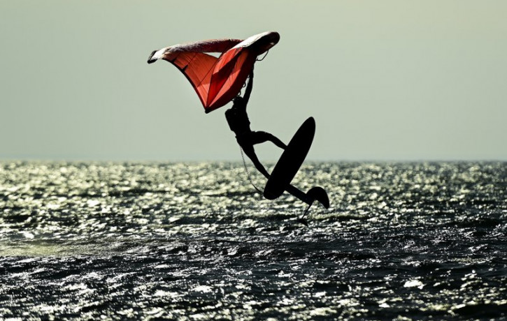 A wing-surfer catches some air on lake Ontario at Cherry Beach on a warm fall day during the COVID-19 pandemic in Toronto on Friday, Nov. 20, 2020.