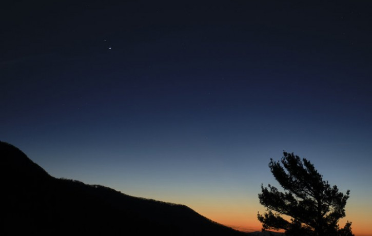 In this Sunday, Dec. 13, 2020 photo made available by NASA, Saturn, top, and Jupiter, below, are seen after sunset from Shenandoah National Park in Luray, Va.