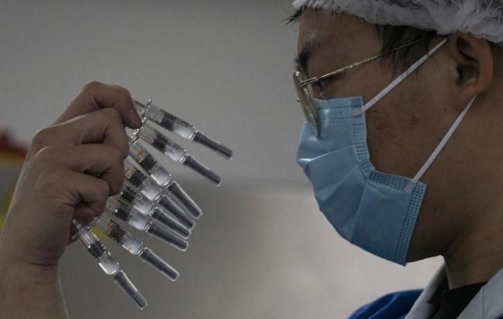 A worker inspects syringes of a vaccine for COVID-19 produced by Sinovac at its factory in Beijing on Thursday, Sept. 24, 2020.