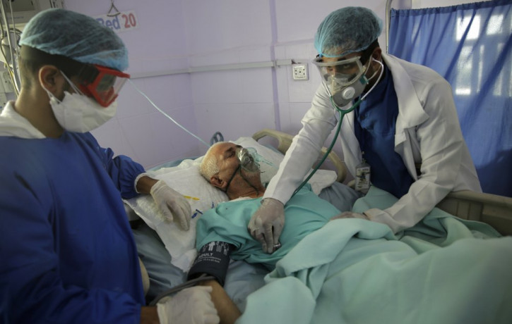 In this June 14, 2020, file photo, medical workers attend to a COVID-19 patient in an intensive care unit at a hospital in Sanaa, Yemen.