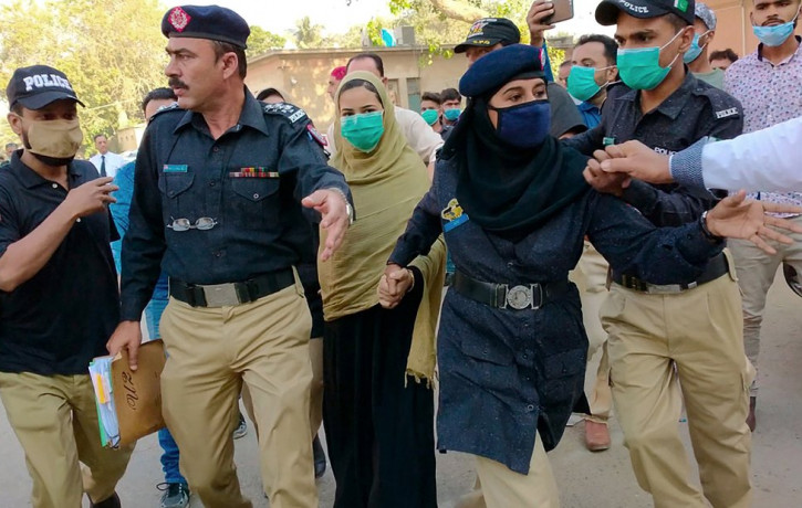 Police officers escort Arzoo Raja, background center, after her appearance in Sindh High Court, in Karachi, Pakistan, on Nov. 3, 2020.
