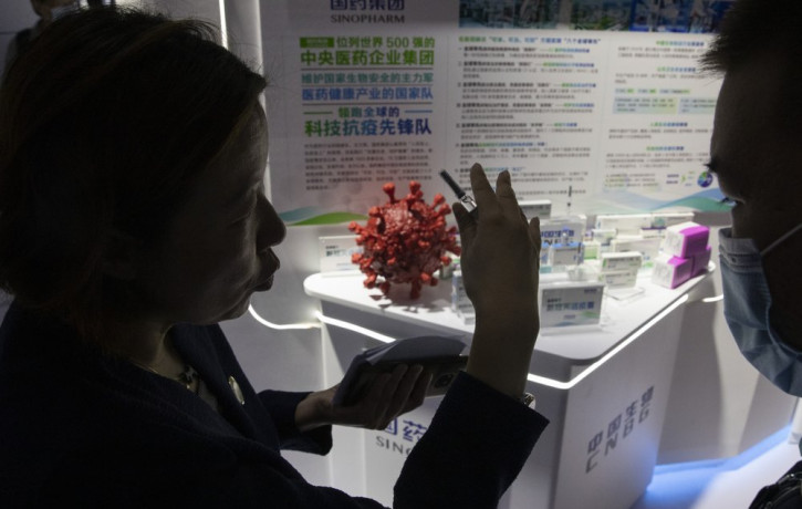 A promoter talks about the COVID-19 vaccine produced by Sinopharm subsidiary CNBG during a trade fair in Beijing on Sunday, Sept. 6, 2020.
