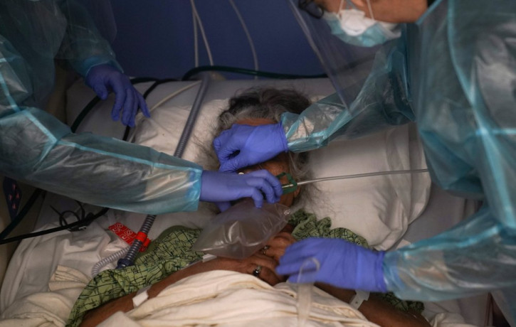 Two nurses put a ventilator on a patient in a COVID-19 unit at St. Joseph Hospital in Orange, Calif. Thursday, Jan. 7, 2021.