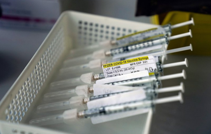 Syringes containing the Pfizer-BioNTech COVID-19 vaccine sit in a tray in a vaccination room at St. Joseph Hospital in Orange, Calif., Thursday, Jan. 7, 2021.