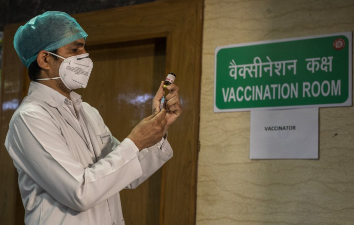 In this Jan. 8, 2021, file photo, a health worker performs a trial run of COVID-19 vaccine delivery system in New Delhi, India. The global death toll from COVID-19 has topped 2 million.