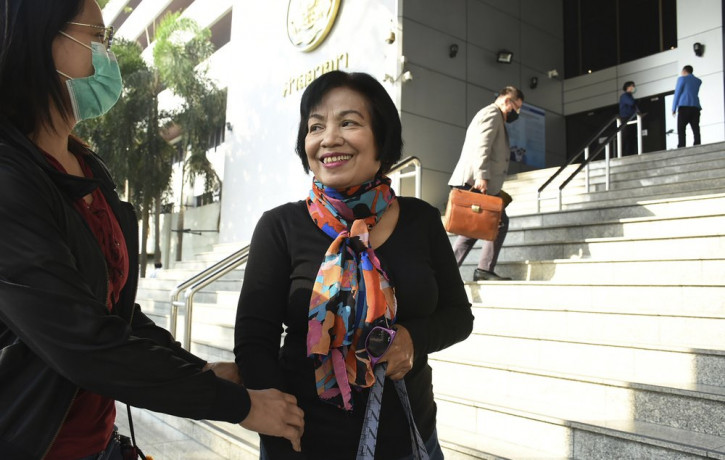 A woman identified only by her first name Anchan, right, talks to her friend as she arrives at the Bangkok Criminal Court in Bangkok, Thailand, Tuesday, Jan. 19, 2021.
