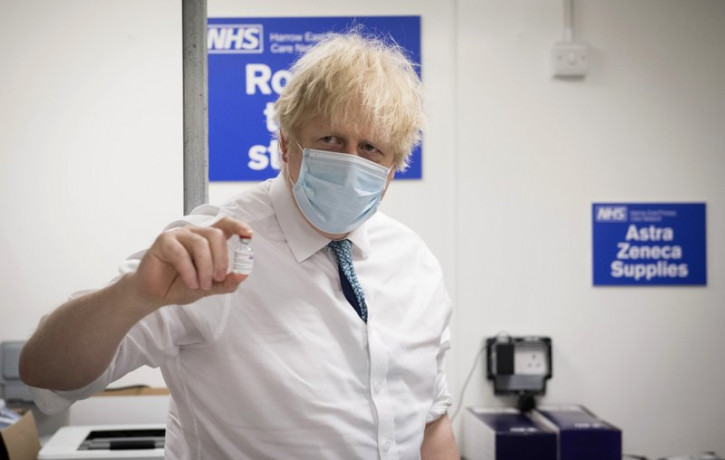 In this Monday, Jan. 25, 2021 file photo, Britain's Prime Minister Boris Johnson holds a vial of the Oxford AstraZeneca COVID-19 vaccine, during a visit to Barnet FC's ground at the Hive in L