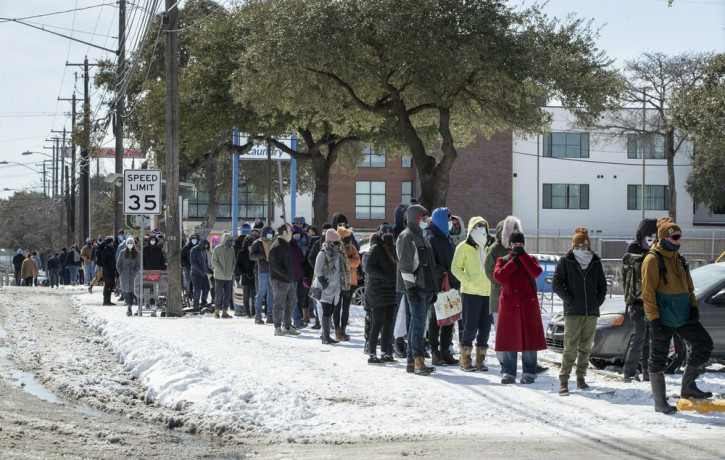 People wait in a long line to buy groceries at H-E-B on South Congress Avenue during an extreme cold snap and widespread power outage on Tuesday, Feb. 16, 2021, in Austin, Texas.