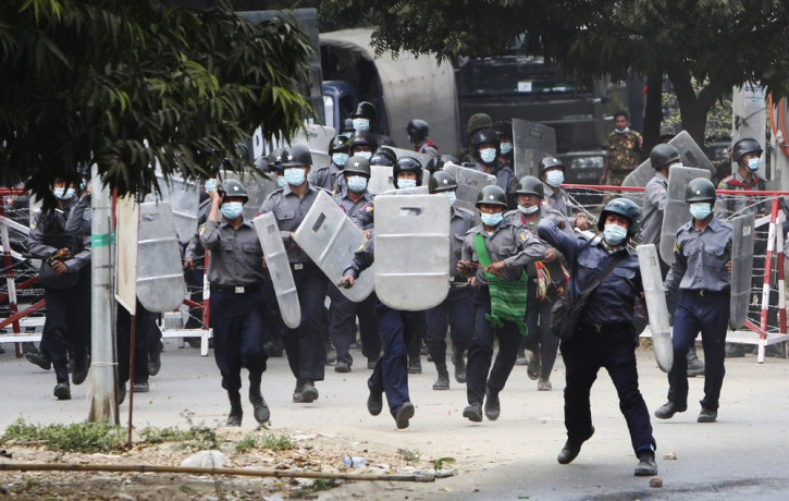 Police charge forward to disperse protesters in Mandalay, Myanmar on Saturday, Feb. 20, 2021.