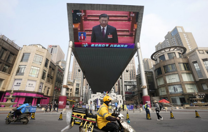 Chinese President Xi Jinping is seen on a big screen during a live broadcast of the closing session of the National People's Congress in Beijing on Thursday, March 11, 2021.