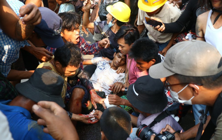 Anti-coup protesters surround an injured man in Hlaing Thar Yartownship in Yangon, Myanmar Sunday, March 14, 2021.