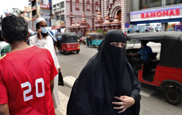 A burqa clad Sri Lankan Muslim woman walks in a street of Colombo, Sri Lanka, Saturday, March 13, 2021.