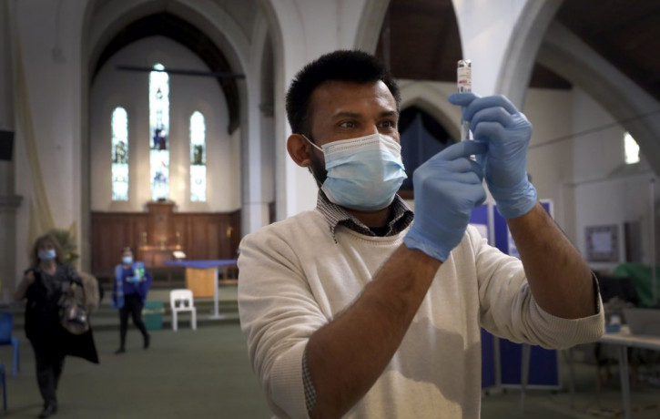 Pharmacist Rajan Shah prepares a syringe of the AstraZeneca vaccine at St John's Church, in Ealing, London, Tuesday, March 16, 2021.