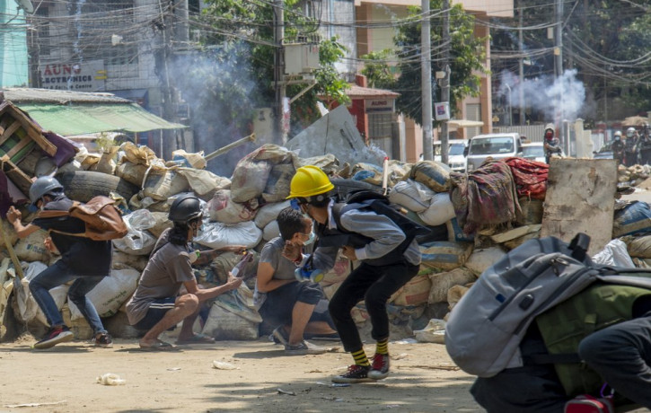 Armed riot policemen charge after firing teargas a rubber bullets as anti-coup protesters abandon their makeshift barricades and run in Yangon, Myanmar Tuesday, March 16, 2021.