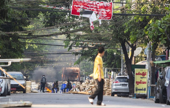 Police and military forces occupy a road block barricade in Yangon, Myanmar, Friday, March 19, 2021.