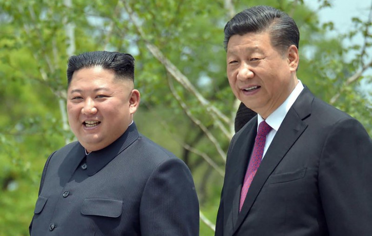 In this June 21, 2019, file photo provided by the North Korean government, North Korean leader Kim Jong Un, left, and Chinese President Xi Jinping stroll in the premises of Kumsusan guest hou