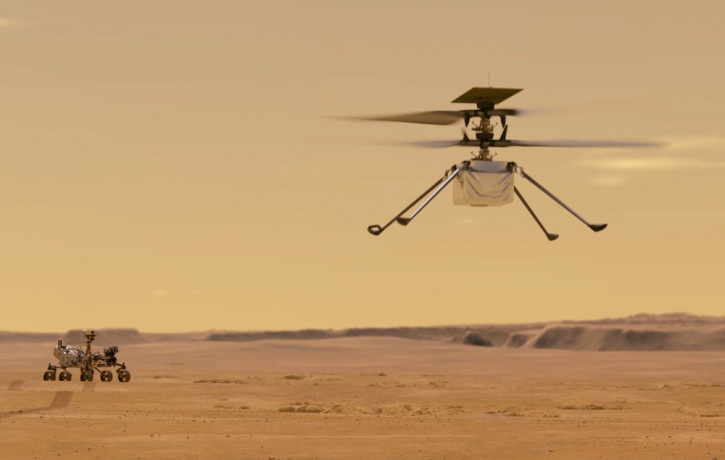 This illustration made available by NASA depicts the Ingenuity helicopter on Mars which was attached to the bottom of the Perseverance rover, background left. It will be the first aircraft to