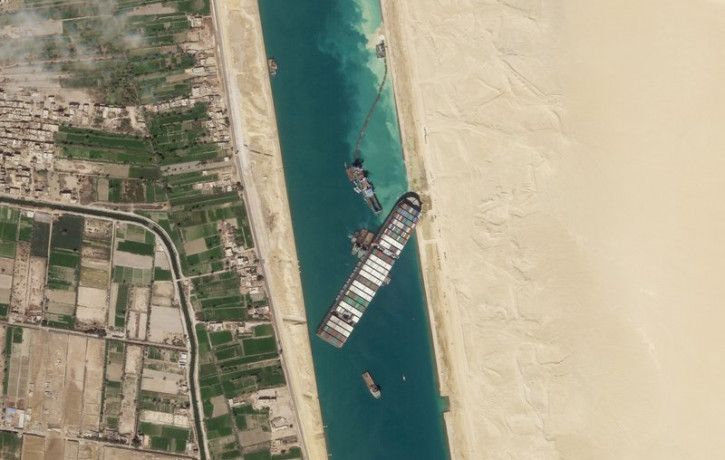 In this March 28, 2021, satellite file image from Planet Labs Inc, the cargo ship MV Ever Given sits stuck in the Suez Canal near Suez, Egypt.