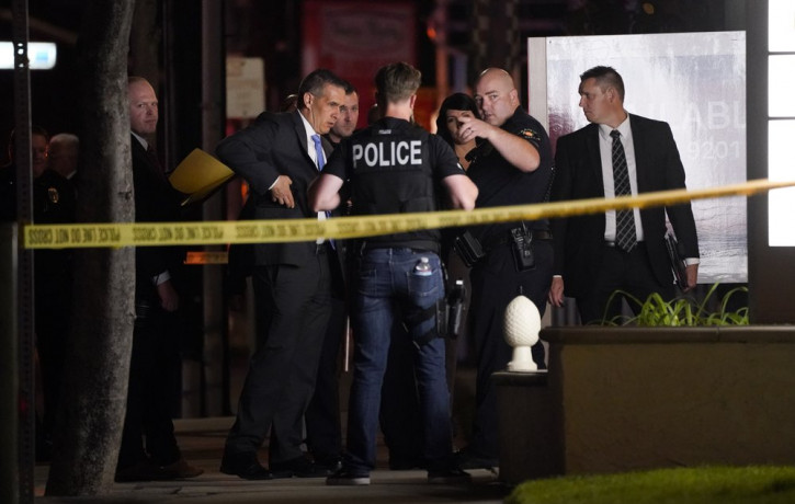 Investigators gather outside an office building where a shooting occurred in Orange, Calif., Wednesday, March 31, 2021.