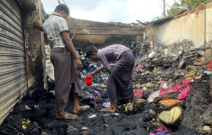 People inspect the debris after a fire in a makeshift market near a Rohingya refugee camp in Kutupalong, Bangladesh, Friday, April 2, 2021.