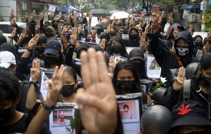 Anti-coup protesters flash three-fingered symbol of resistance as they gather to pray for those who died during a protest against the military in Yangon, Myanmar, Monday, April 5, 2021.