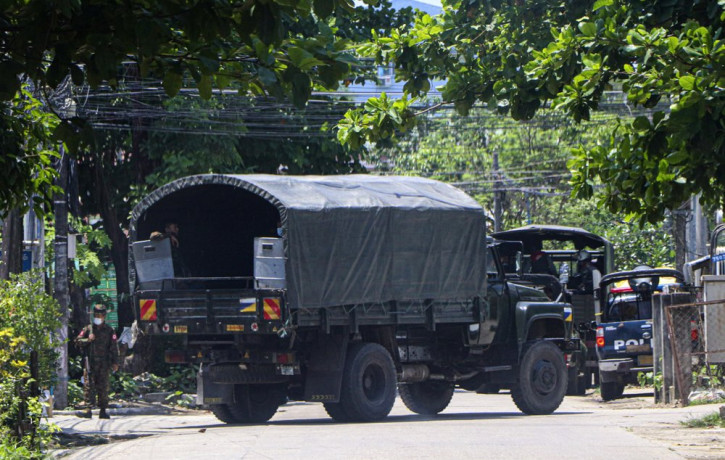 A police vehicle is parked at a road in South Okkalapa township to block anti-coup protesters' gathering in Yangon, Myanmar, Friday, April 9, 2021.