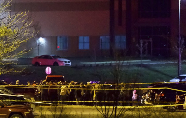 People stand outside a FedEx facility near Indianapolis International Airport after a shooting with multiple victims was reported late Thursday night, April 15, 2021.
