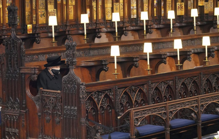 Britain's Queen Elizabeth II sits alone in St. George’s Chapel during the funeral of Prince Philip, the man who had been by her side for 73 years, at Windsor Castle, Windsor, England, Saturda