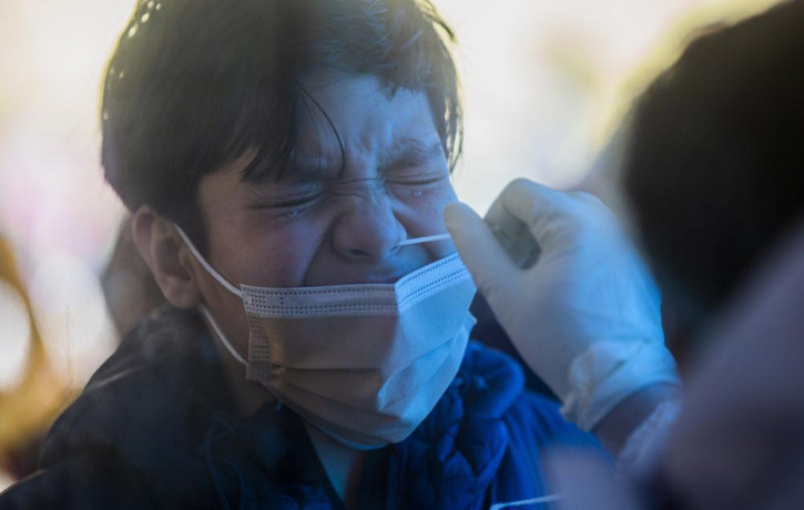 A health worker takes a nasal swab sample of Mohammad Faris to test for COVID-19 in Srinagar, India.