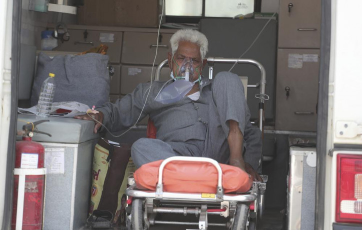 A COVID-19 patient waits inside an ambulance to be attended to and admitted into a dedicated COVID-19 government hospital in Ahmedabad, India, Thursday, April 22, 2021.