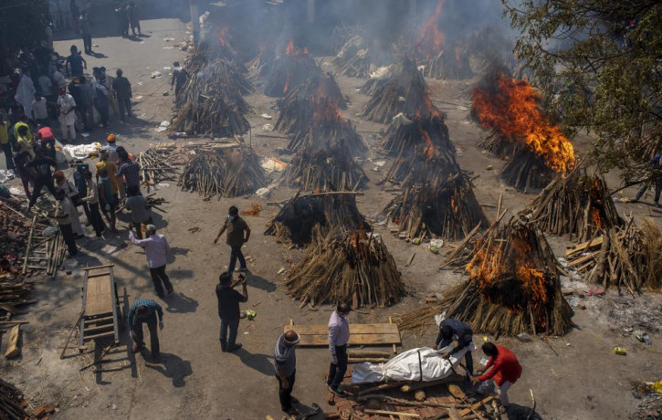 Multiple funeral pyres of victims of COVID-19 burn at a ground that has been converted into a crematorium for mass cremation in New Delhi, India, Saturday, April 24, 2021.
