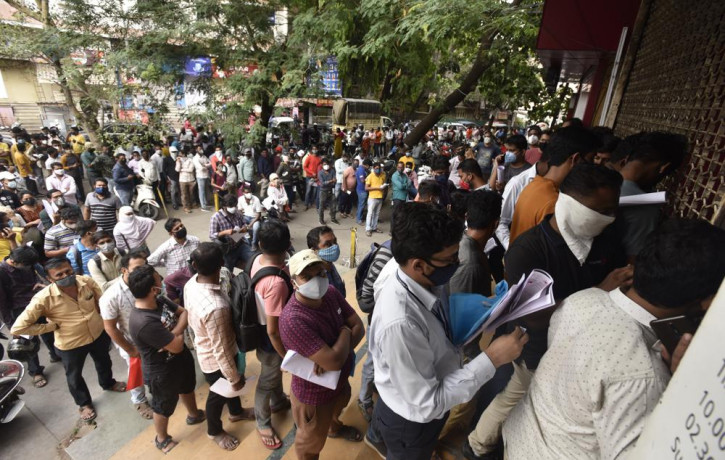 In this April 8, 2021 file photo, people wait in queues outside the office of the Chemists Association to demand necessary supply of the anti-viral drug Remdesivir, in Pune, India.