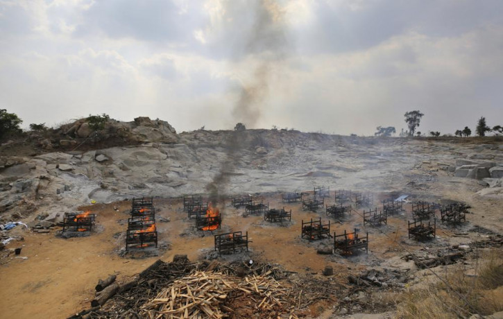 Funeral pyres of twenty-five COVID-19 victims burn at an open crematorium set up at a granite quarry on the outskirts of Bengaluru, India, Wednesday, May 5, 2021.