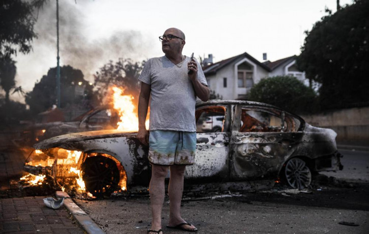 Jacob Simona stands by his burning car during clashes with Israeli Arabs and police in the Israeli mixed city of Lod, Israel Tuesday, May 11,2021.