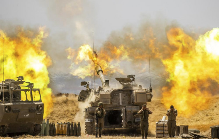 An Israeli artillery unit fires toward targets in Gaza Strip, at the Israeli Gaza border, Wednesday, May 12, 2021.