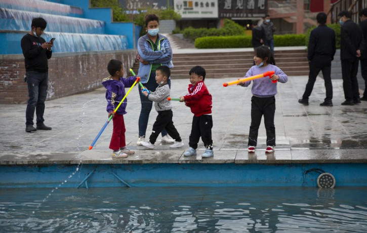 Children play with water toys at a public square in Aksu in western China's Xinjiang Uyghur Autonomous Region, Tuesday, April 20, 2021.