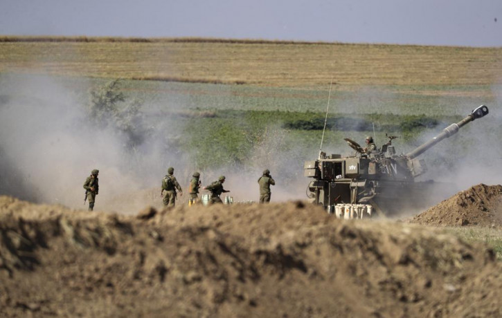 An Israeli artillery unit fires toward targets in Gaza Strip, at the Israeli Gaza border, Saturday, May 15, 2021.