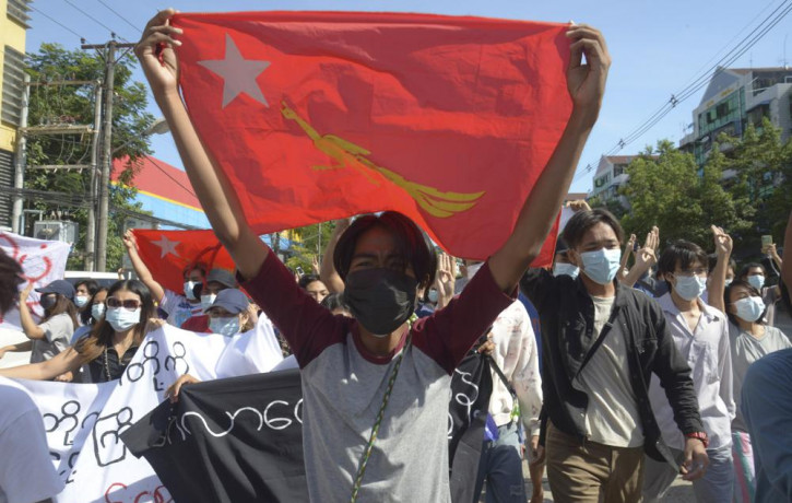 Anti-coup protesters display a party flag of the National League for Democracy (NLD) during a demonstration in Yangon, Myanmar, Friday, May 14, 2021.