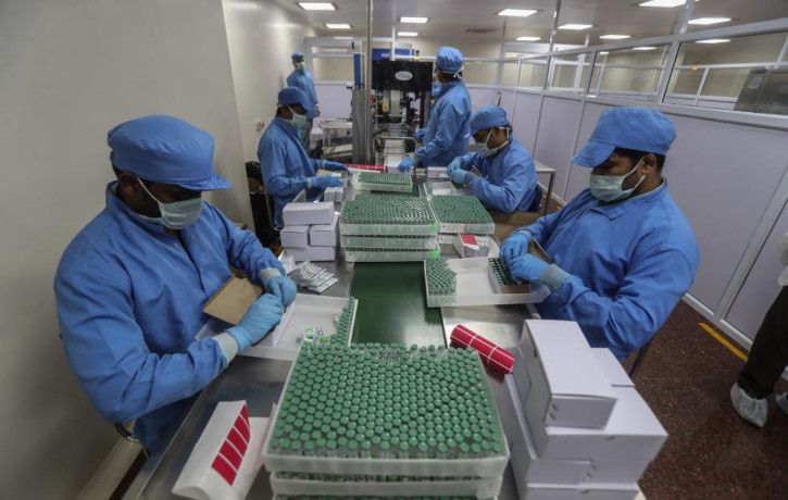 In this Jan. 21, 2021, file photo, employees pack boxes containing vials of Covishield, a version of the AstraZeneca vaccine at the Serum Institute of India in Pune, India.